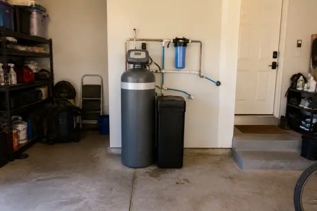 Newly installed water softener system with PEX piping in a residential garage in Mesa, AZ.