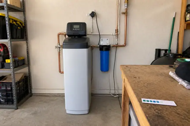 Water softener unit installed on a residential garage wall in Mesa, AZ.