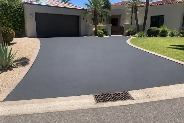 Newly resurfaced smooth asphalt driveway in front of a residential home in Scottsdale, AZ.