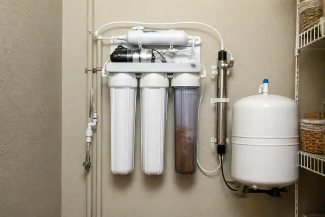 Residential water purification system with filters and tubing mounted on a pantry wall in Tempe, AZ.