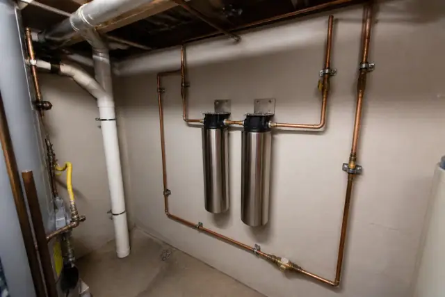 Stainless steel water filtration system with copper piping in an Avondale, AZ apartment mechanical room.