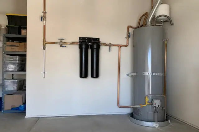 Water filtration system with two carbon canisters and copper piping installed in a Goodyear, AZ garage.