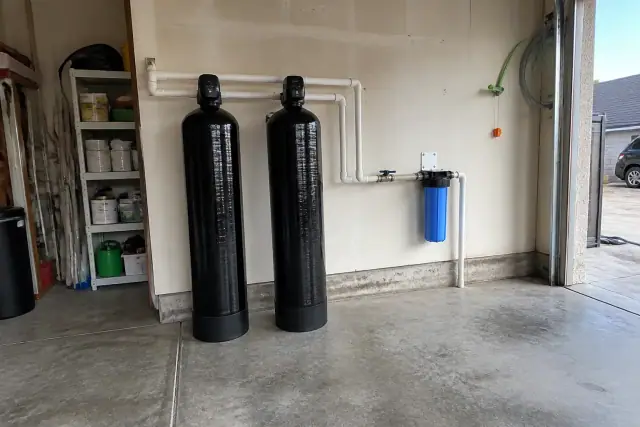 Whole house water filtration system installed in a residential garage in Tempe, AZ.