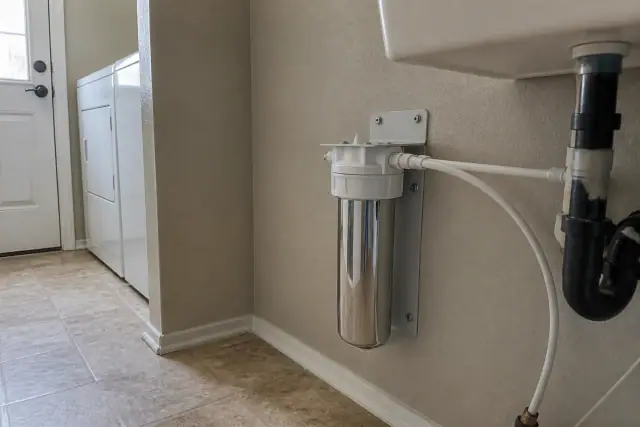 Water filtration system installed under a laundry room sink in Tempe, AZ.