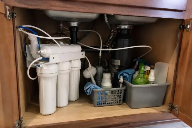 Newly installed water filtration system with plumbing and canisters under a kitchen sink in a Tempe, AZ home.