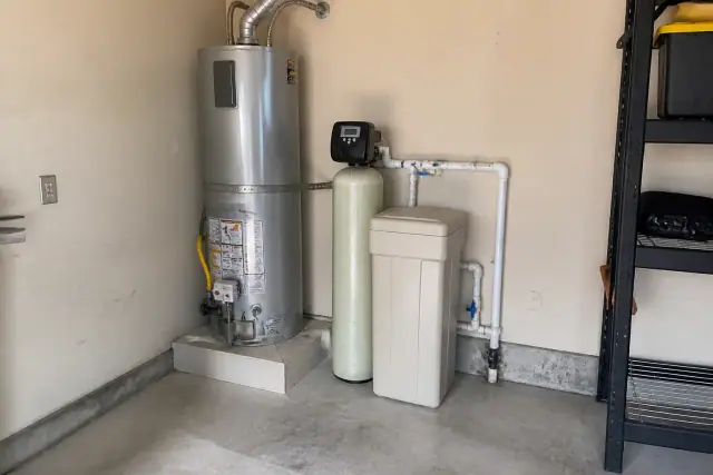 Salt-based water softener installed next to a water heater in a residential garage in Tempe, AZ.
