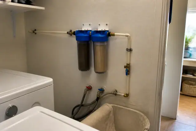 Sediment pre-filter system with clear canisters and PEX piping installed in a laundry room in Tempe, AZ.