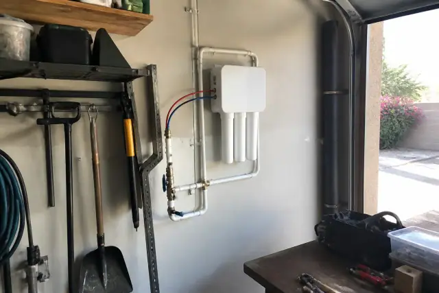 Tankless reverse osmosis water filtration system installed on a garage wall in Tempe, AZ.