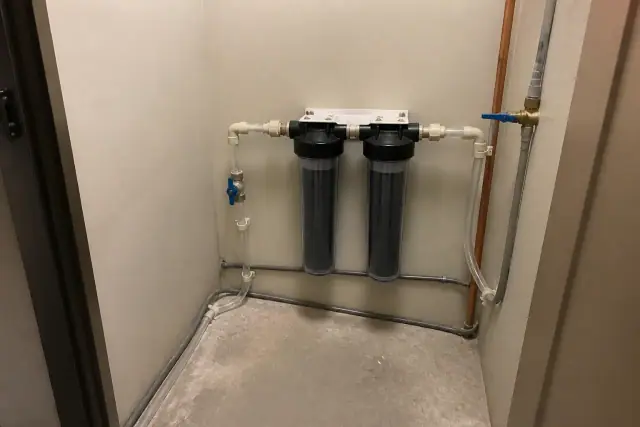 Carbon filter installation mounted on the wall inside an office utility closet in Tempe, AZ.