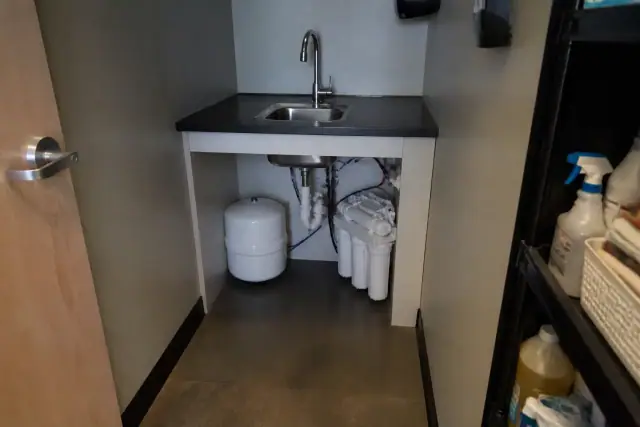 Reverse osmosis water filtration system installed under a utility sink in a Tempe, AZ office closet.