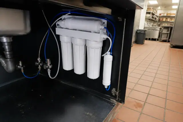 Under-sink reverse osmosis water filtration system installed in a restaurant cabinet in Tempe, AZ.