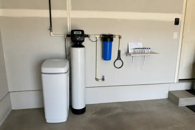 Water softener and filtration system installed on a residential garage wall in Avondale, AZ.