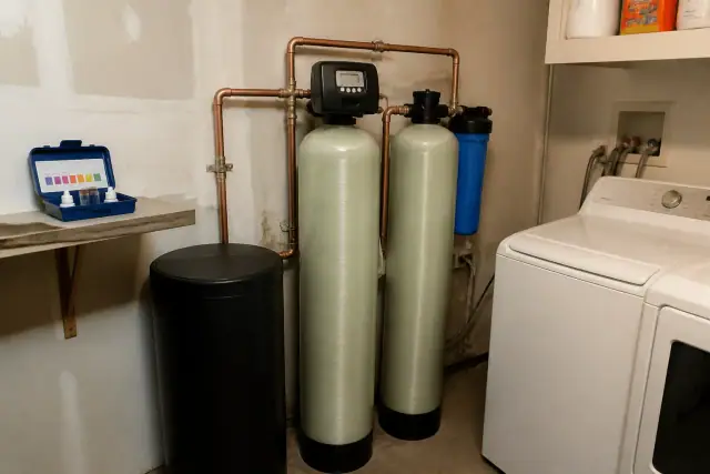 Water softener and filtration system with copper piping installed in a Phoenix, AZ laundry room.