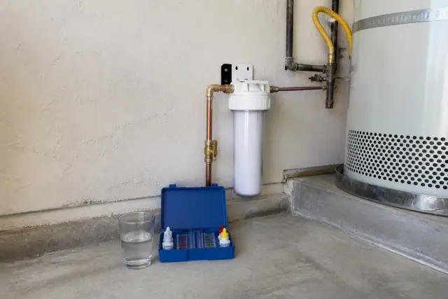 Water filtration system installed next to a water heater in a Tempe, AZ garage.