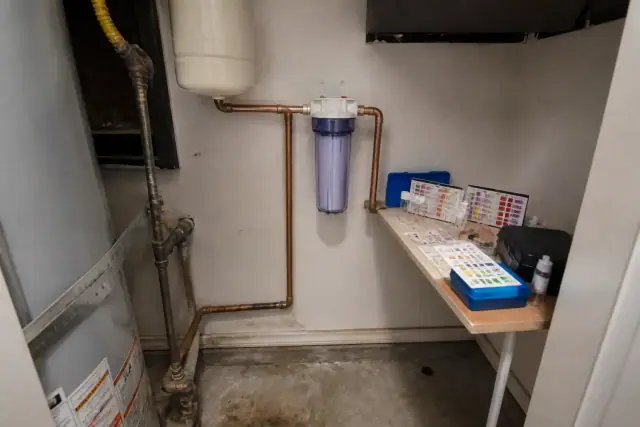 A clear sediment filter installed on copper pipes in an apartment utility closet in Tempe, AZ.
