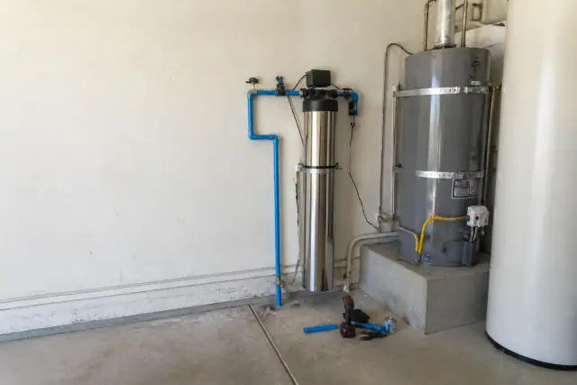 Whole-house carbon water filter installed next to a water heater in a Tempe, AZ garage.