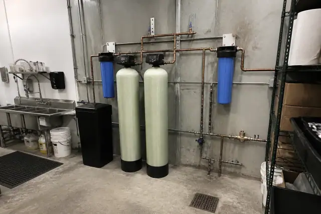 Commercial water filtration system with tanks and copper piping installed in a restaurant back room in Avondale, AZ.